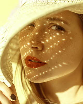 a woman covering her face with her hat